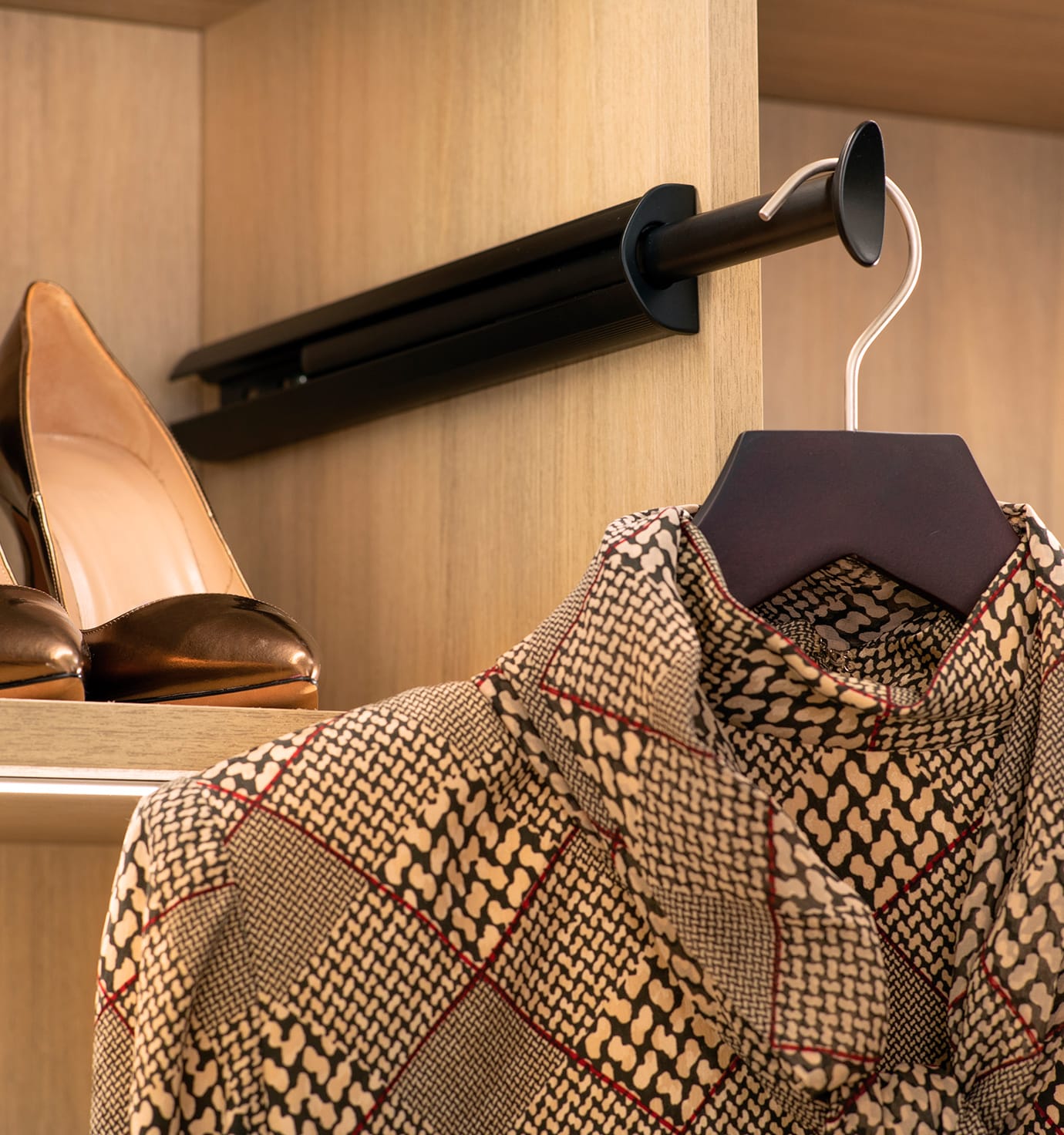Tailored rack for clothing with integrated shelves and LED ribbon lights by California Closets
