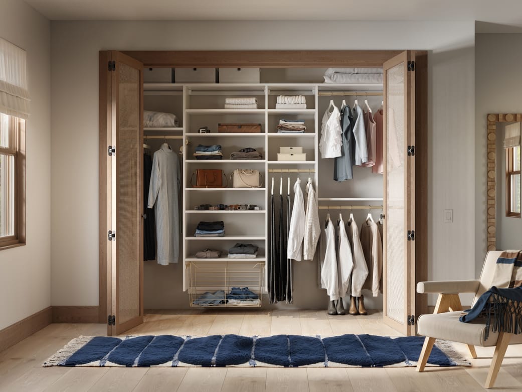 Simple reach in closet layout with open shelving and clothes baskets by California Closets