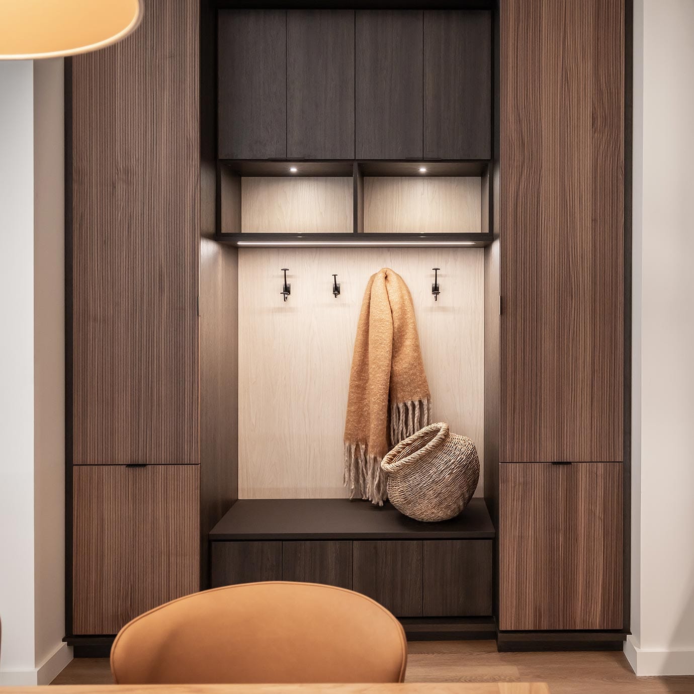 Custom storage bench for entryway made in a dark wood finish by California Closets