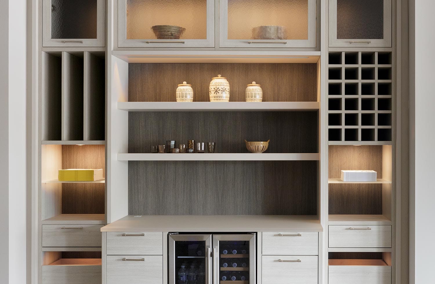 Custom pantry layout with glass cabinets and wine cubbies with storage from California Closets