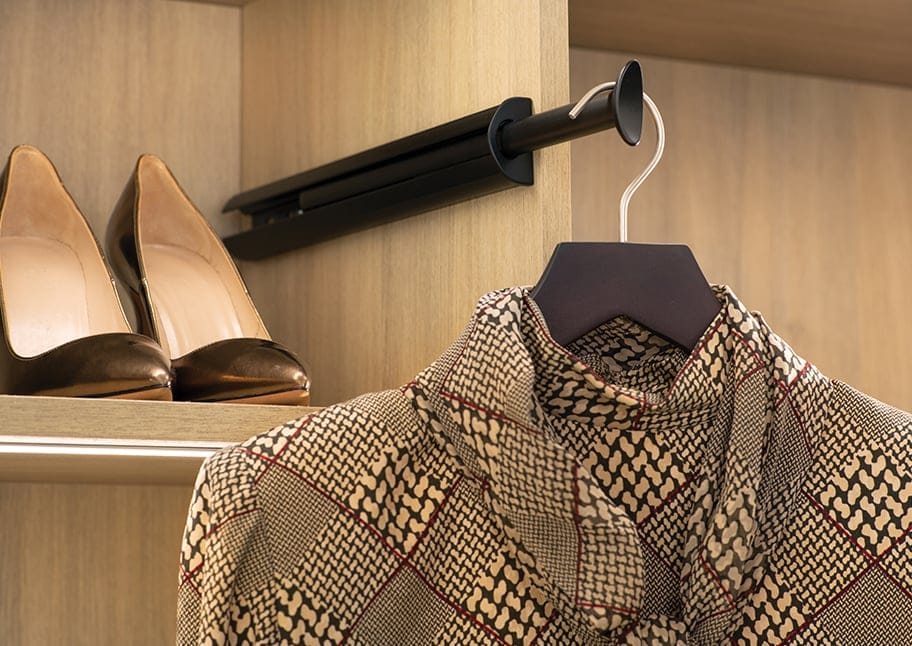 Shirt hanging on a clothing valet rack with shoe storage in background by California Closets
